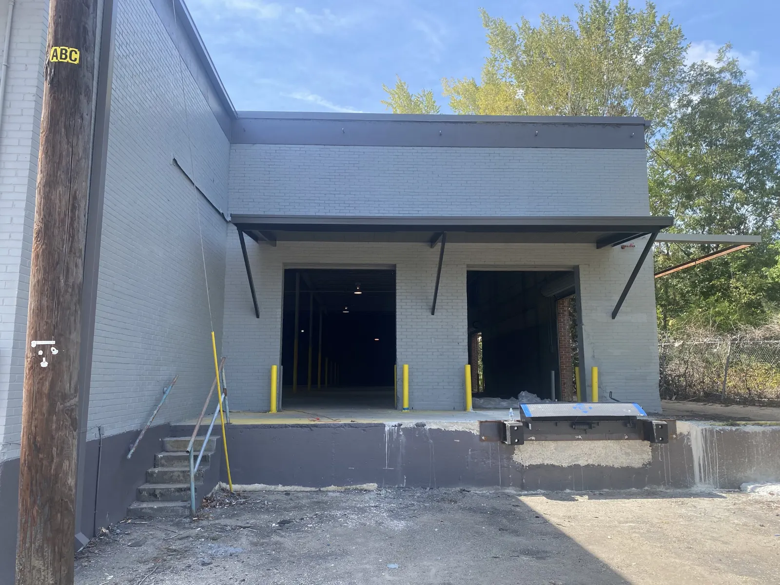 Bracketed aluminum awnings over the loading dock doors of a commercial building