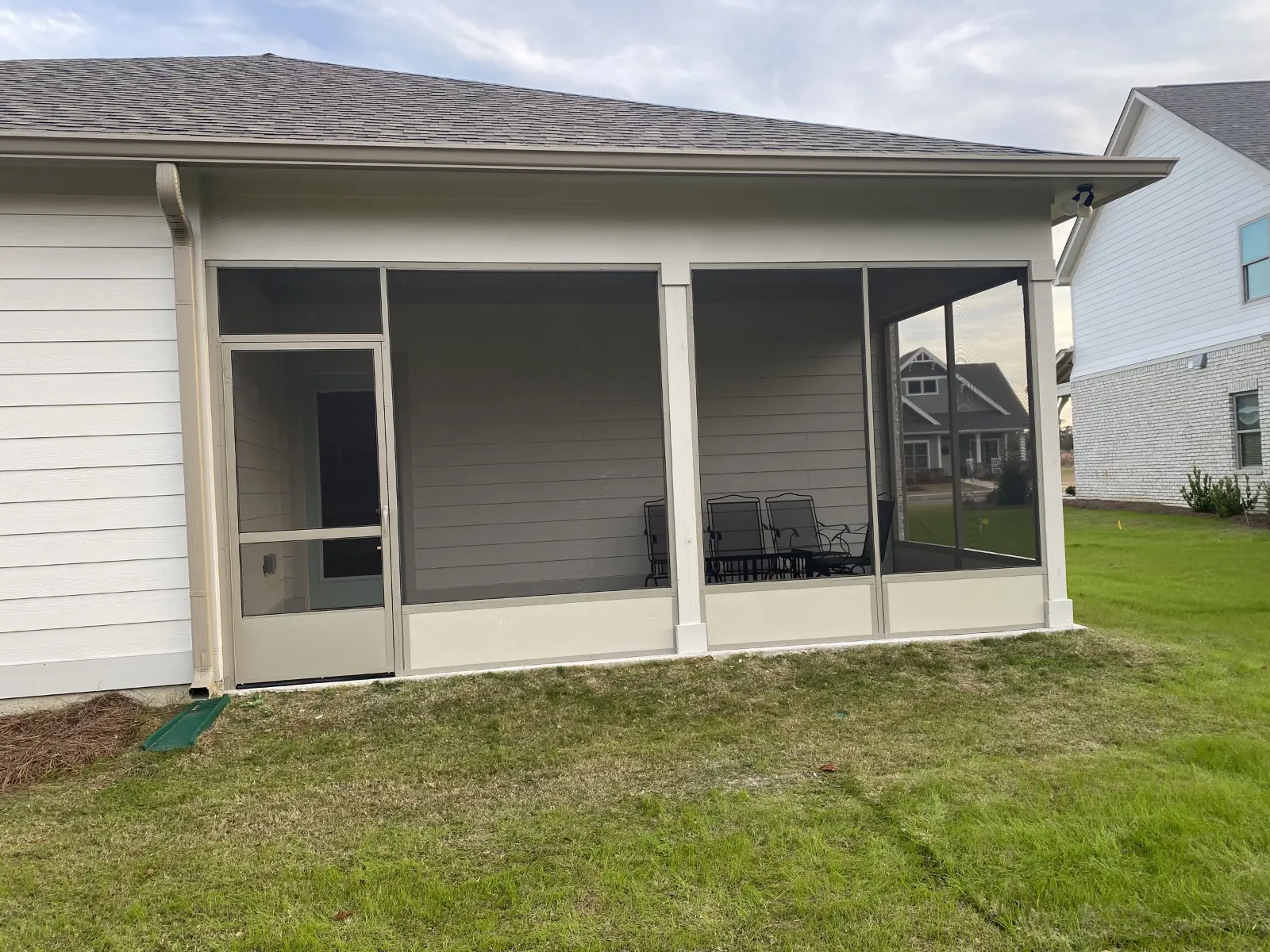 Aluminum screen room with kick panels and a screen door on a new home